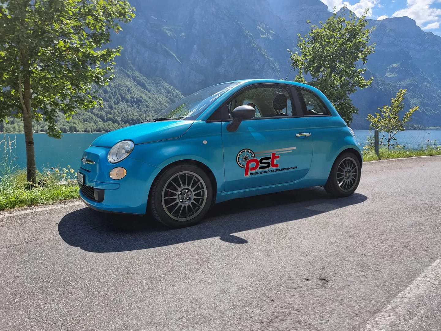 Fiat 500 in Himmelblau, parkiert an Aussicht am See